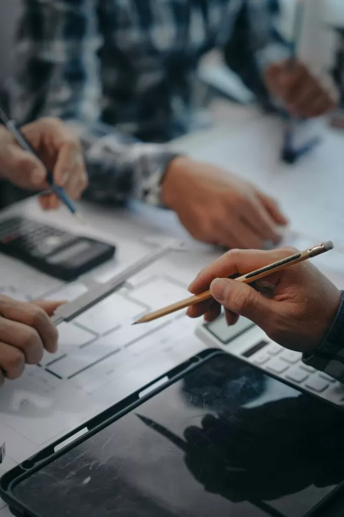 Team of engineers in a meeting, drawing blueprints for condo, apartment, and house construction.